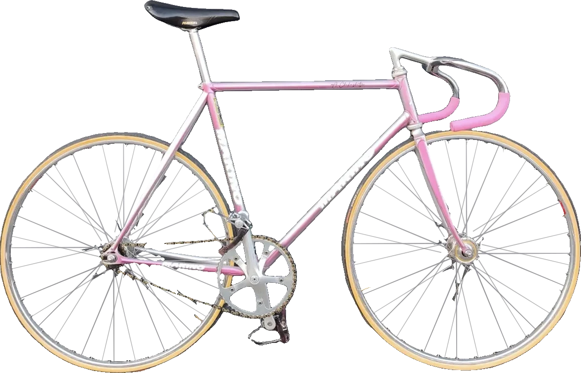 Pink-silbern schimmerndes Marino-Rennrad vor einer grauen Toreinfahrt mit Notausgang-Schild, schwarzer Sattel, gelbe Reifen.